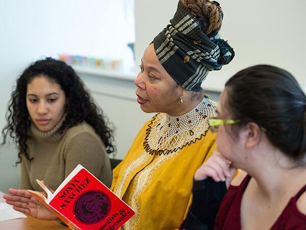 Provost and Dean of the Faculty Tracey Hucks discusses a book with students.