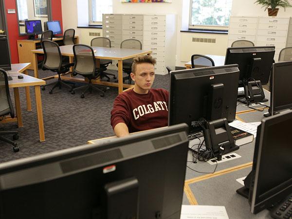 A Colgate student browsing the shelves in the Game-Geyer Library