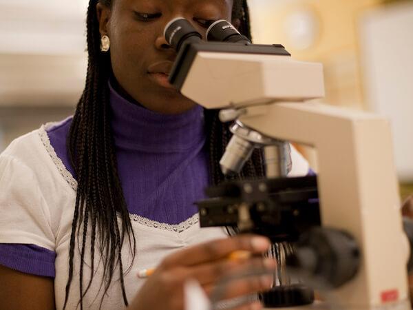 A Colgate student uses a microscope to analyze samples in the laboratory 