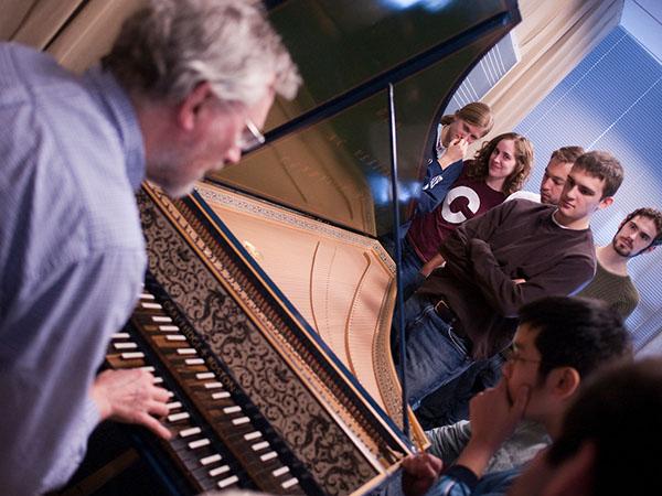 Professor Joscelyn Godwin gives students a close up look at a harpsichord as part of his Music History course.