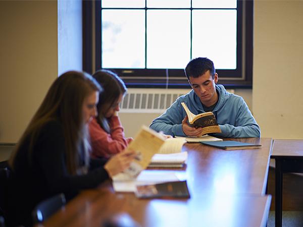 Students review literature in a class led by Professor Hélène Julien