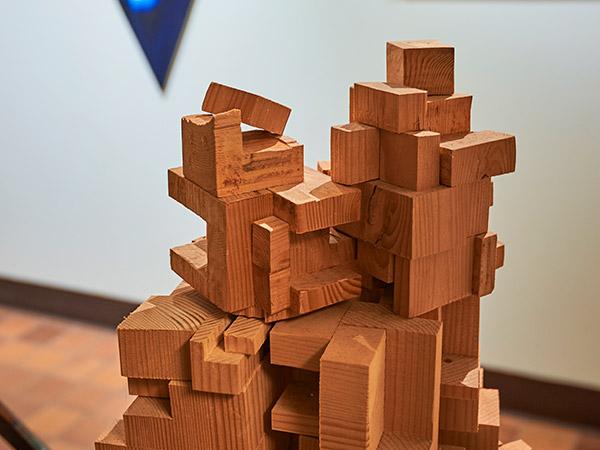 Student artwork, including an interlocking wooden sculpture, on display at Clifford Gallery.