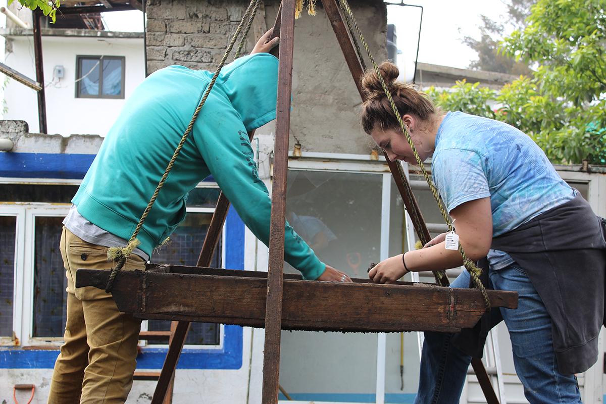 Two students sift material at an archaeological dig in Mexico