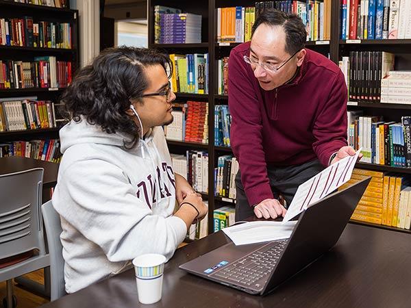A student reviews materials with an adviser in the OUS library