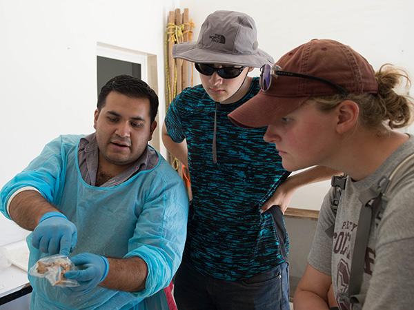 Two students learn how to tell the ages of people based on their bones from physical anthropology and dentistry specialist in Mexico