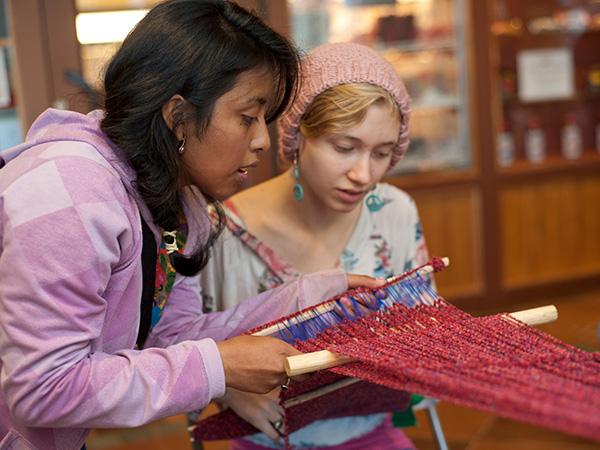 Colgate student being shown weaving techniques in the Coop