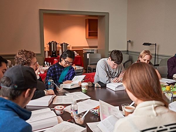 Students closely review the text of Paradise Lost together