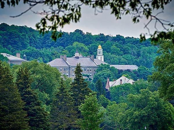 Scenic view of Colgate campus buildings on the hillside amidst the trees