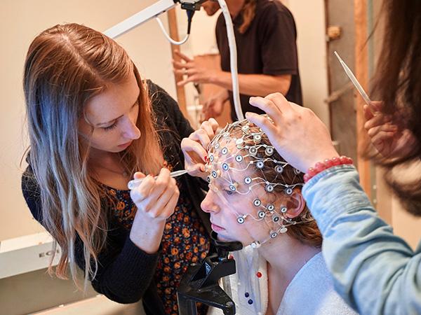 Students prepare a test subject for a brain scan
