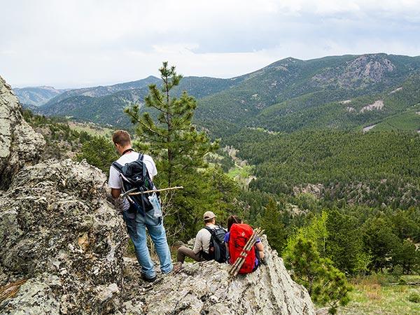 Students on a rock outcrop overlooking mountains and a valley on the geology summer field camp