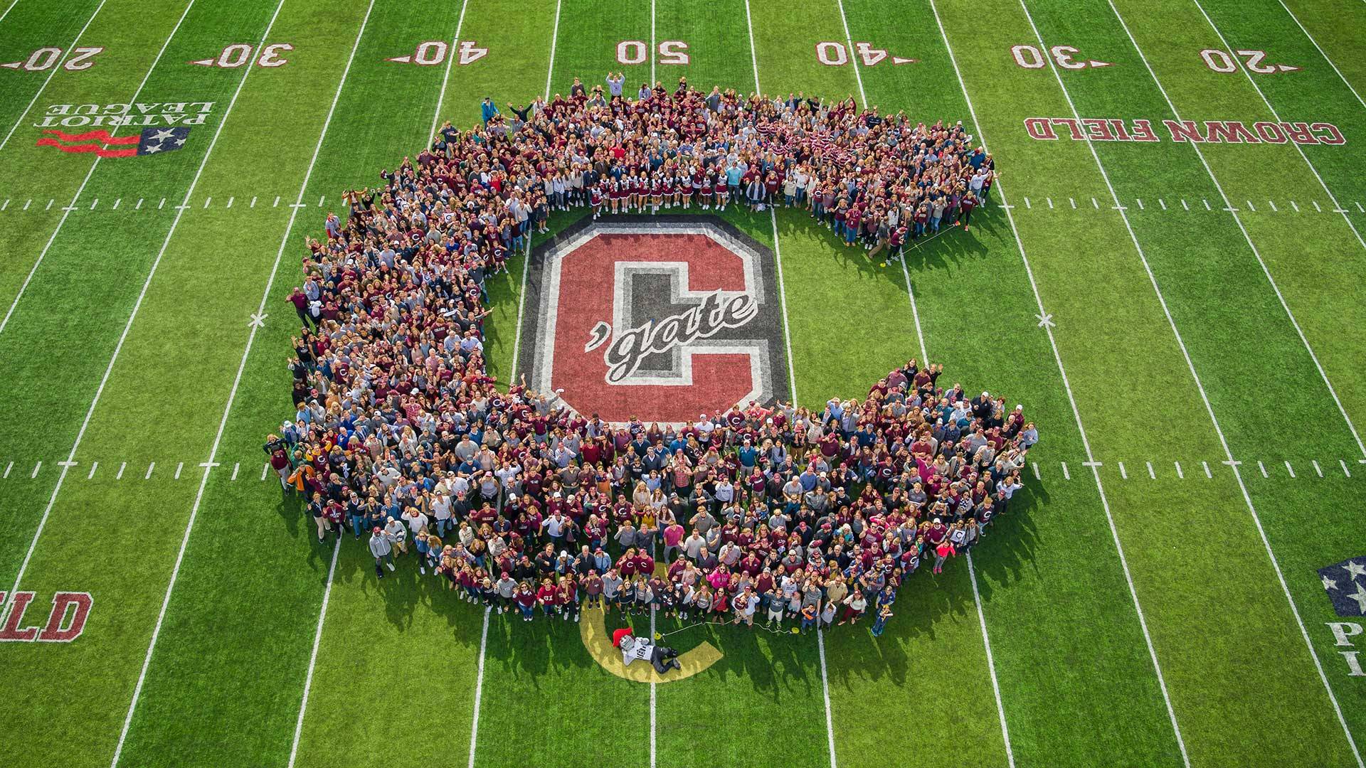 Hundreds of Colgate fans form a giant human C on the field at the 2019 Bicentennial homecoming football game.