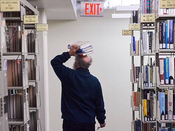 Faculty member from the back with three library books