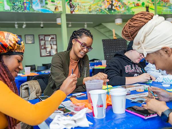 Students work on a mural in the ALANA Cultural Center