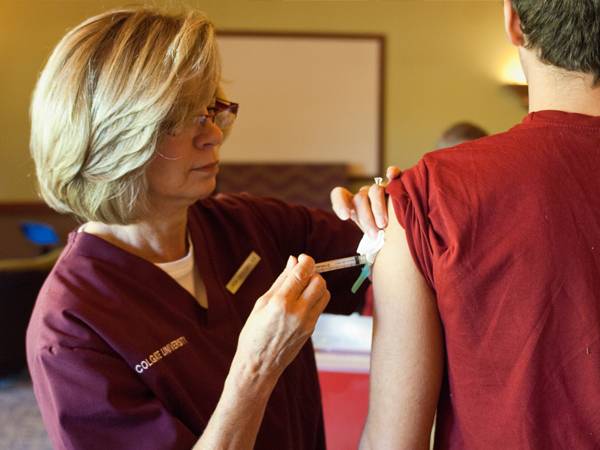 A nurse gives a student a flu shot.