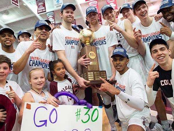 Colgate's men's basketball team poses with the Patriot League championship trophy they won