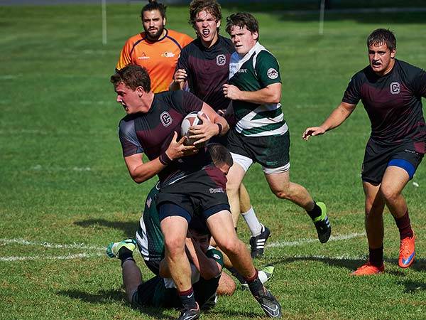A Colgate men's rugby player tries to run through a tackle