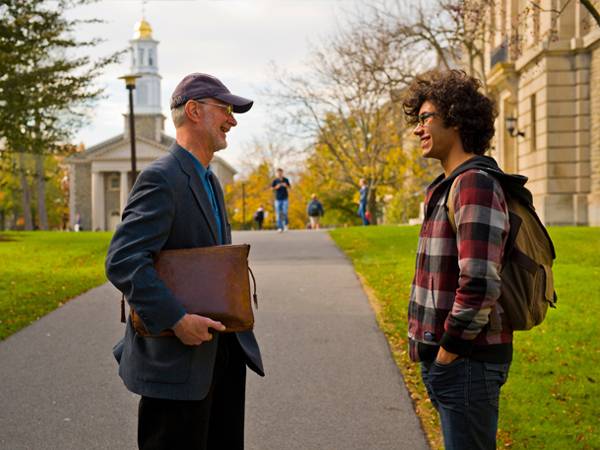 Professor Chris Vecsey chats with a student on the quad.