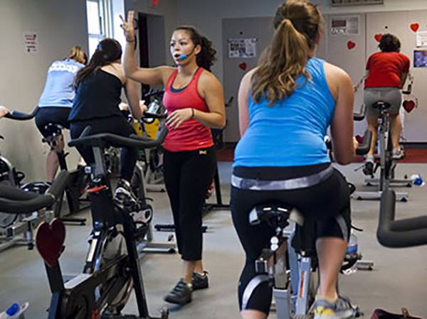 An instructor giving direction to a spinning class