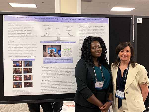 Carrie Keating and a student present a research poster at the APS