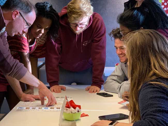faculty and students look at a map on a table