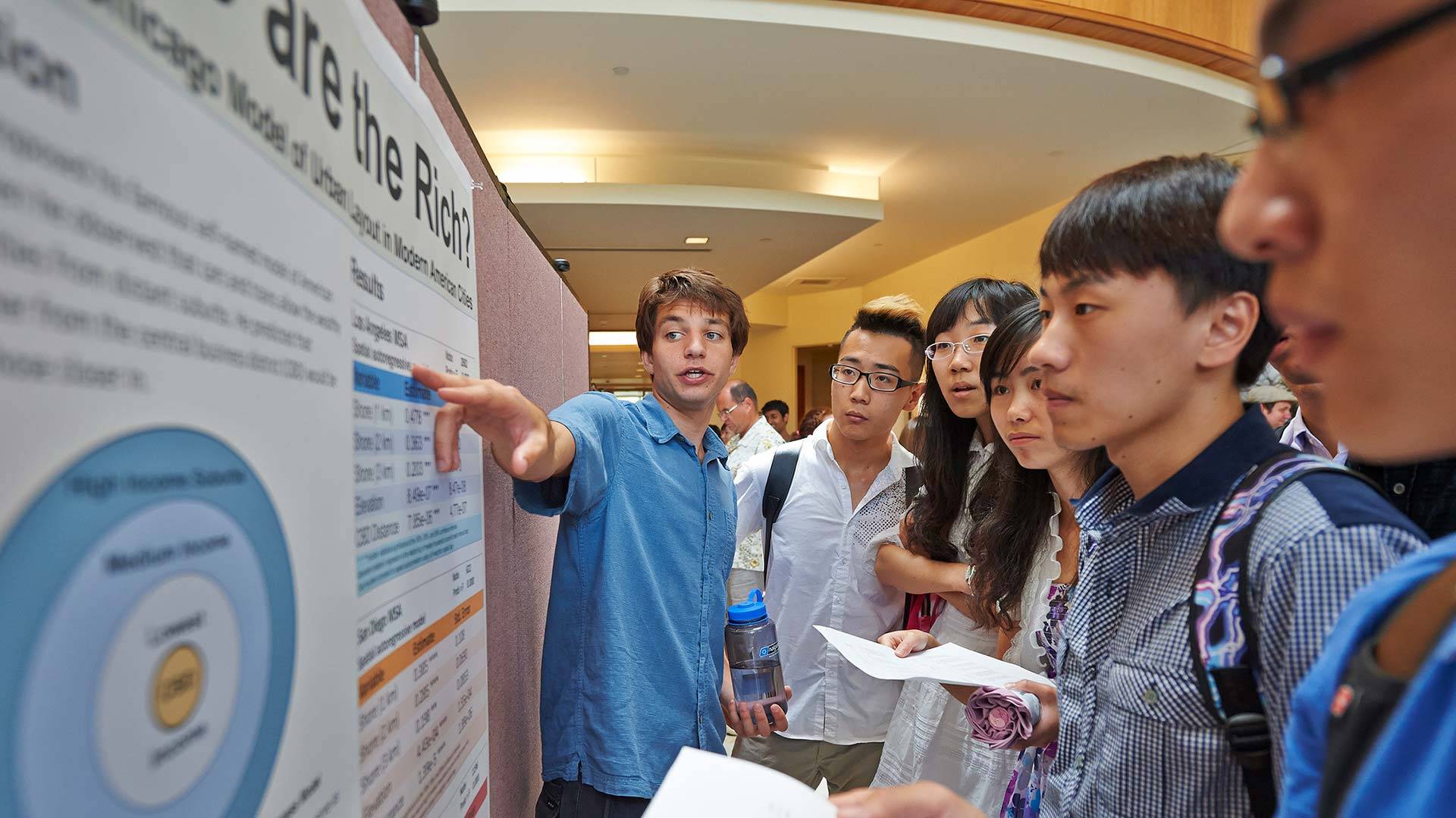 A Colgate student presents a research poster to students visiting Colgate on the Xiamen exchange program.