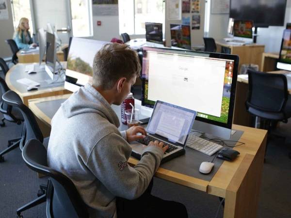 A student works with computers in the DLMC