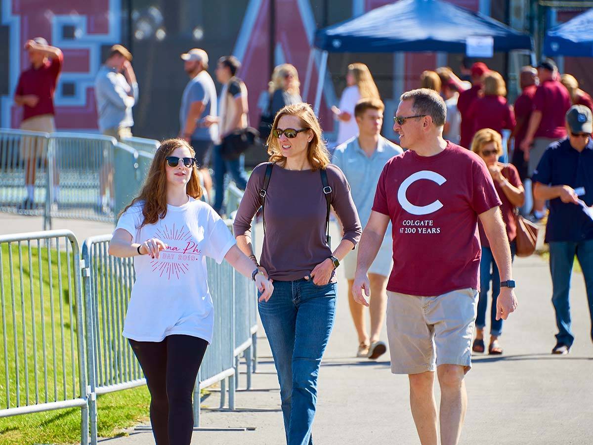 A student with her parents at the Family Weekend football game