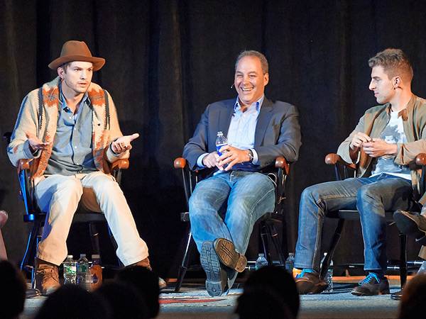 Men on stage, one dressed like a cowboy