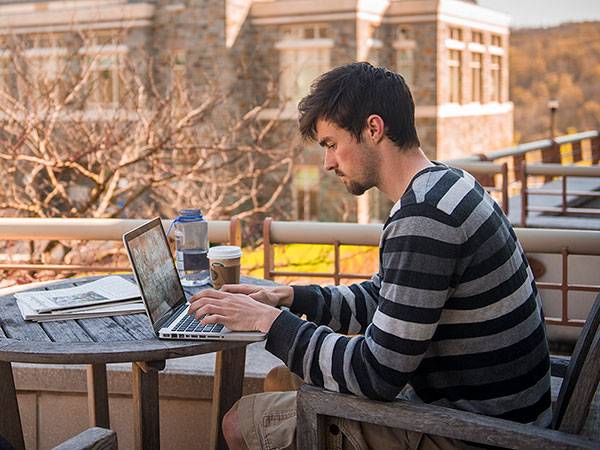 Student working on a laptop outside the Coop