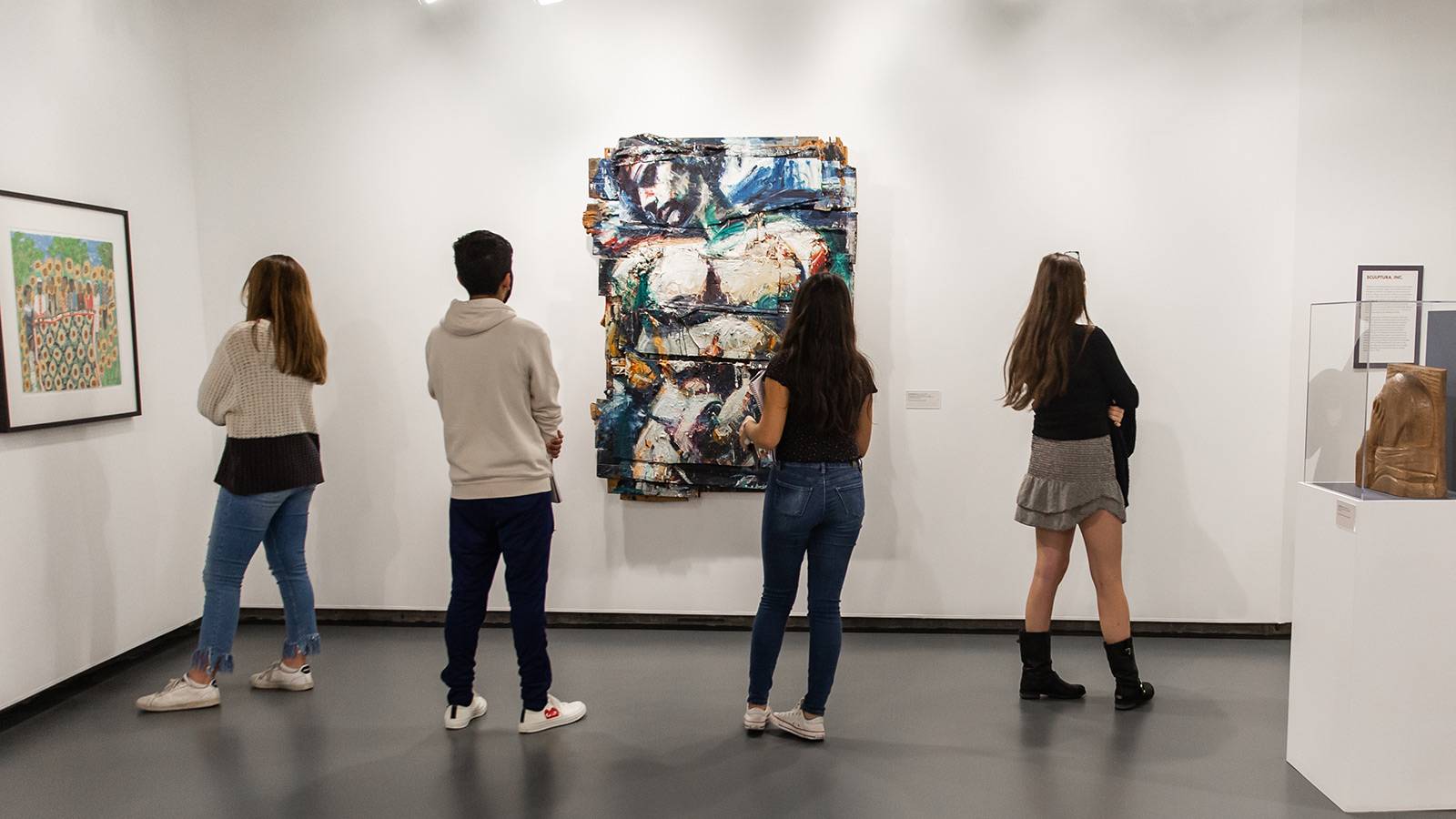 Students pondering art in gallery space