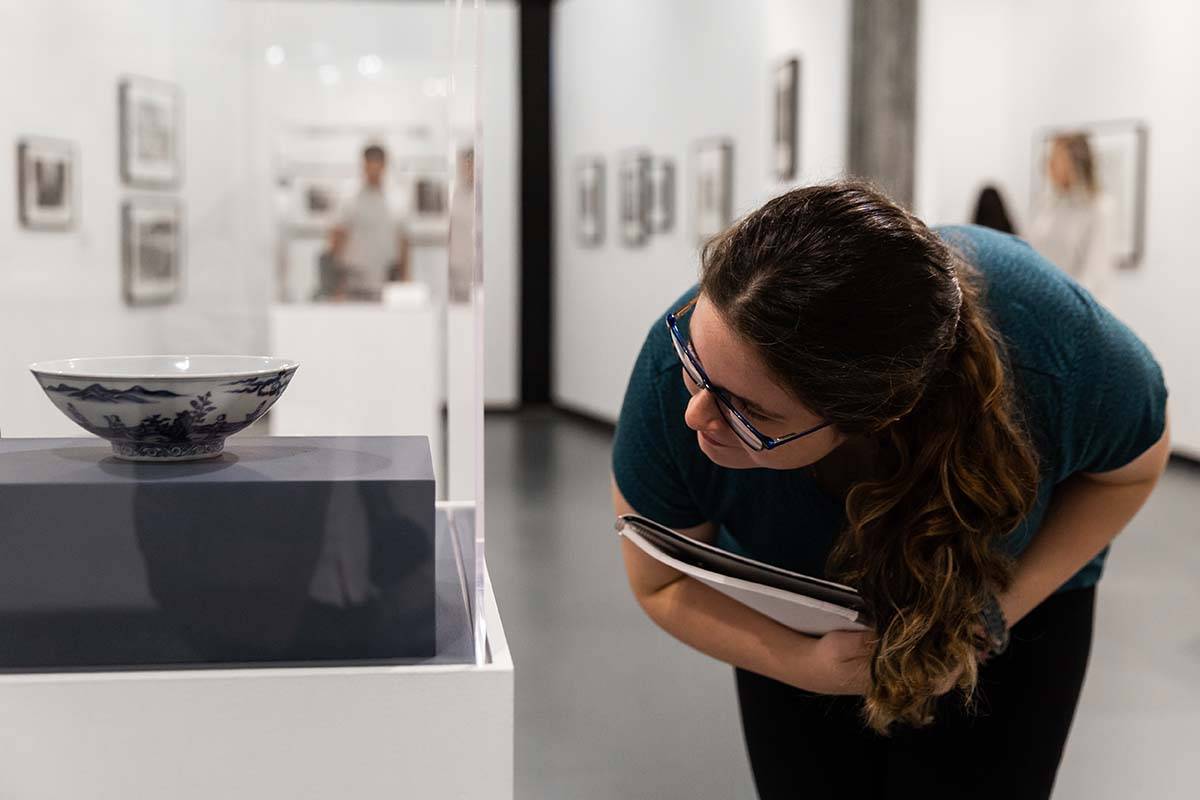 Student peering into object on display in the museum