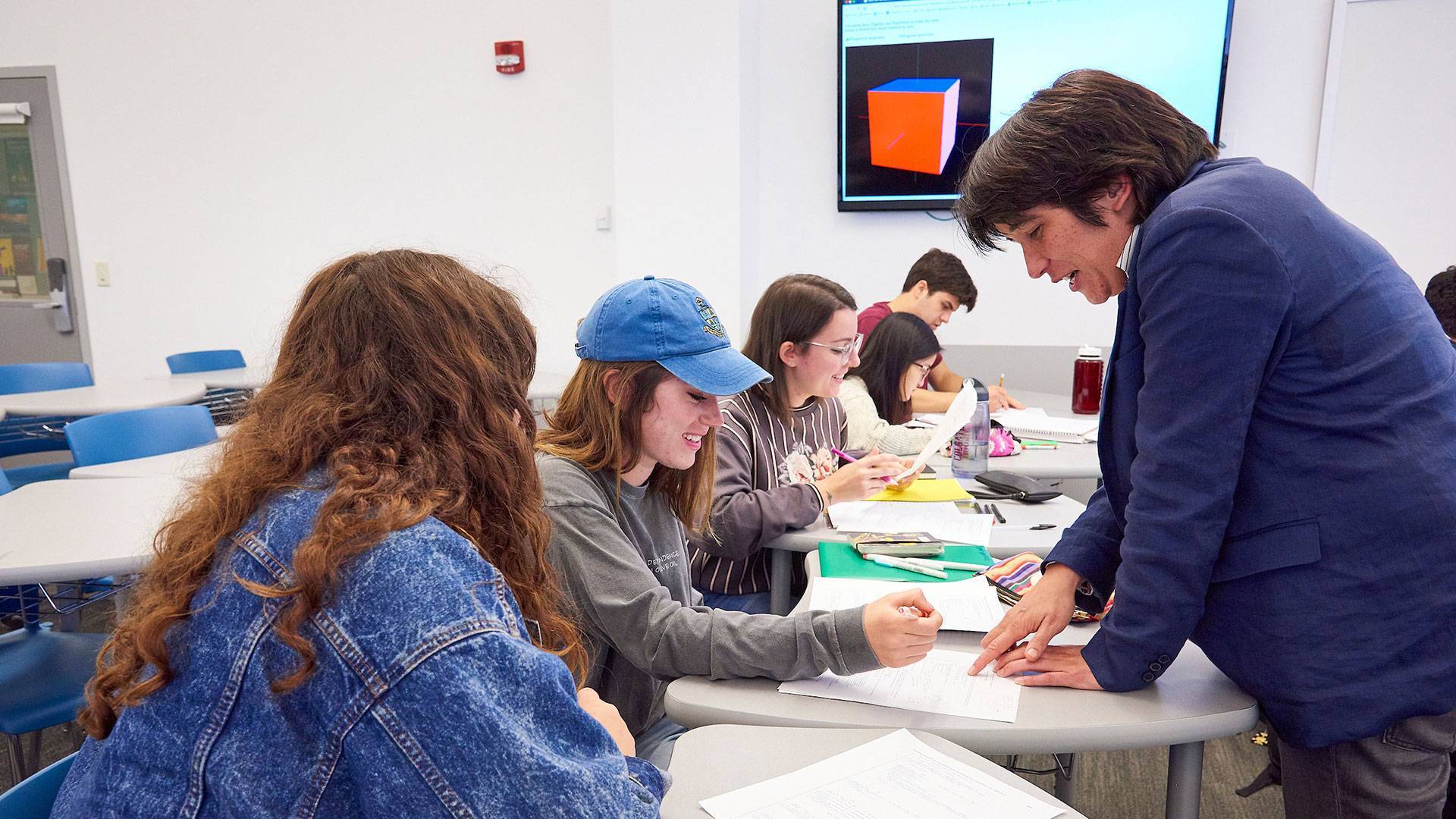 A professor assists students in the classroom