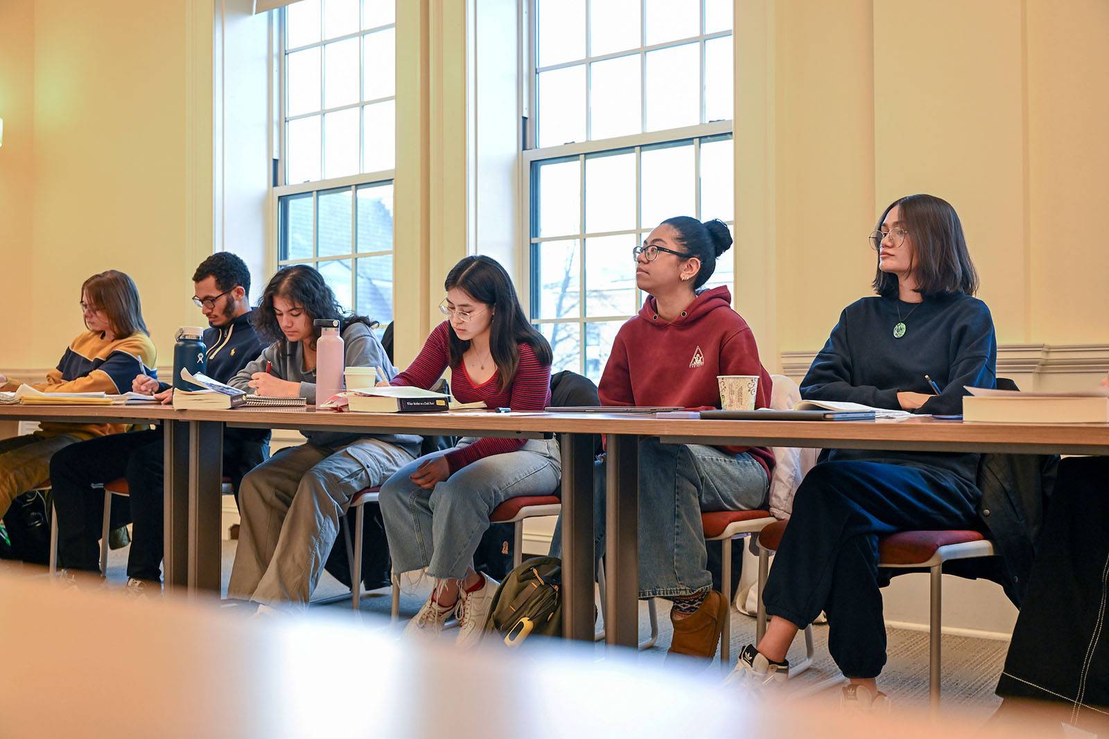 A row of students sit while listening to a lecture