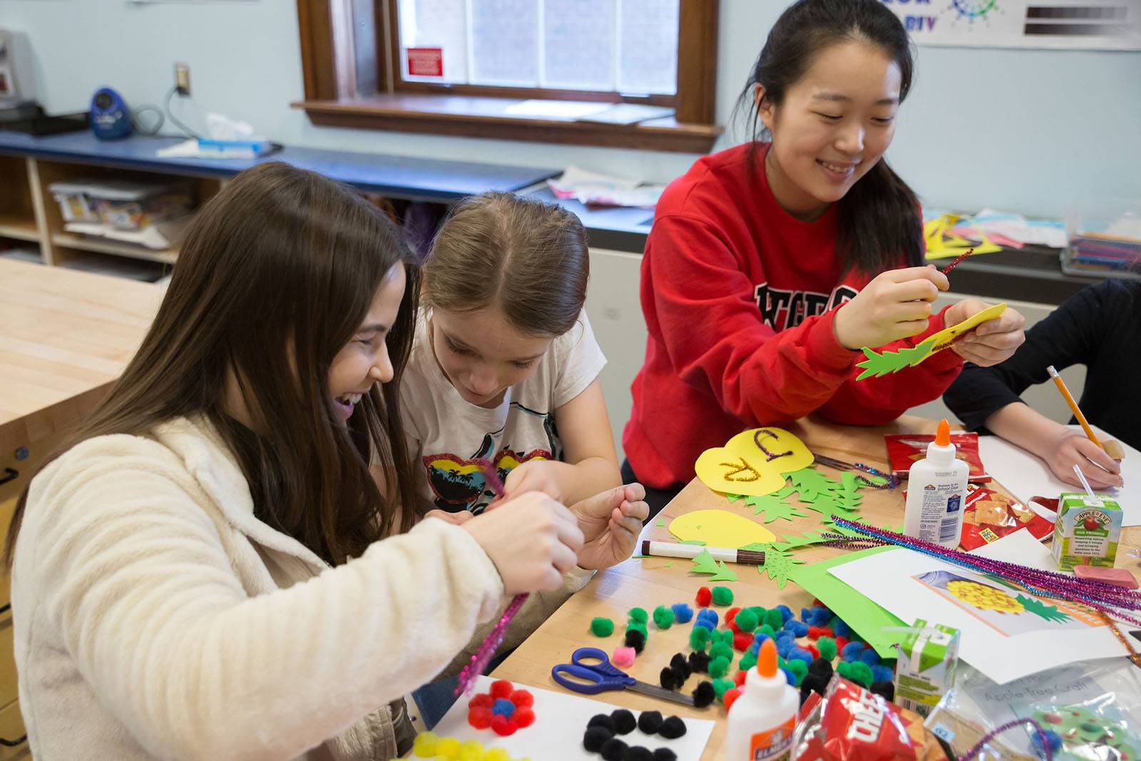 Two Colgate students spend time crafting with public school students
