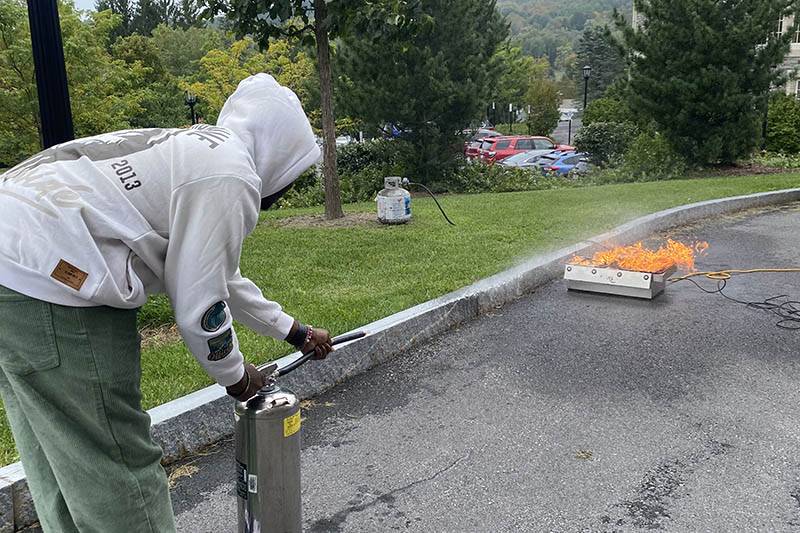 A student learns how to use a fire extinguisher