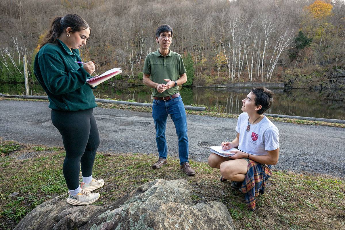 A faculty member with two students doing field research