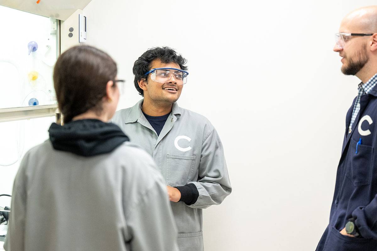 A faculty member with two students in the lab