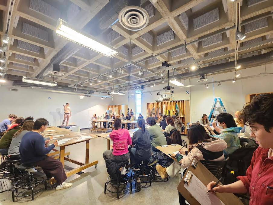 Students drawing model during Queerfest event