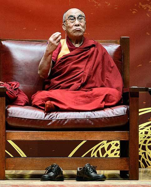 Dalai Lama sitting crossed legged in Stickley chair